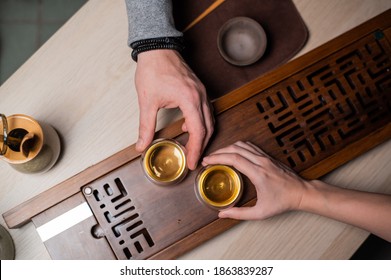 A Mysterious Tea Ceremony For Two. Top View, Harmony Shot With The Hands Of A Man And A Girl Drinking Chinese Tea From Special Bowls