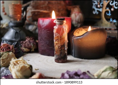 Mysterious Witch's Spell Closed In A Small Glass Bottle With Dried Roses And Magic Candles