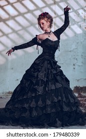 Mysterious Woman Dressed In Gothic Dress Posing In Ruined Building