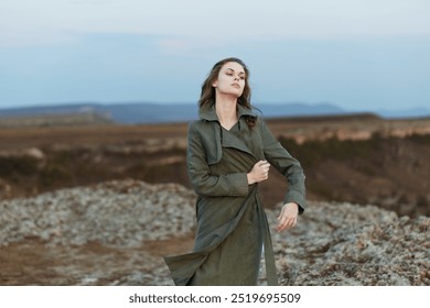 Mysterious woman standing alone on moonlit hilltop in trench coat at night - Powered by Shutterstock