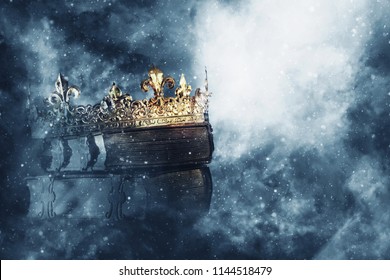 mysteriousand magical image of old crown and book over gothic black background. Medieval period concept - Shutterstock ID 1144518479