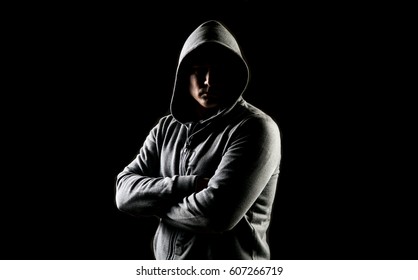 Mystery man posing with hoodie on a black background 