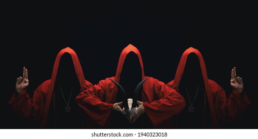 Mystery people in a red hooded cloaks in the dark. Hiding face in shadow. Pointing up with fingers. Satanic symbols. Ghostly figure.