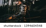 Mystery scarface knight in armor with sword and crossbow in the forest