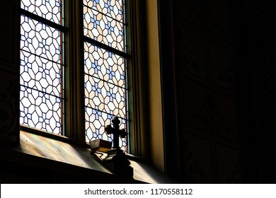 Mystic Cross In The Shadow In Front Of The Stained Transparent Glass In A  Gothic Catholic Cathedral