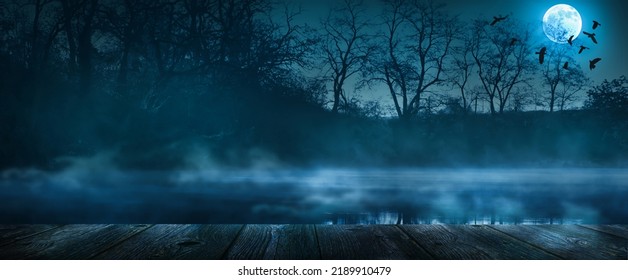 mystic natural halloween background for party invitation card, shining  moonlight on wooden planks, misty lake and trees with copy space for product presentation, halloween party concept banner - Shutterstock ID 2189910479