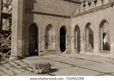 Mystical interior, ruins of facade of abandoned ruined building of ancient castle, mansion. Old ruined walls, corridor with garbage and mud. Ruins Ancient historical building, destroyed by vandals