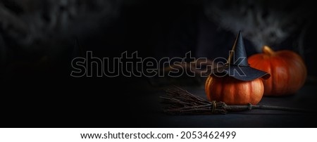 The mystical room of the witch. A decorative photo for Halloween with a hat, pumpkins and a broom. Banner in black and orange colors close-up.