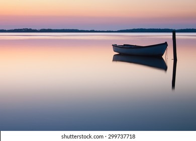 Mystical Sea. Abstract Natural Backgrounds. Moon Scene After Sunset With Still Water And Vintage Boat.