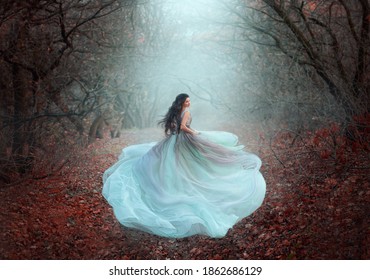 Mystical silhouette of running fairy girl queen in motion. Beautiful woman fantasy princess lush dress. dark deep forest black trees fog orange fallen autumn leaves, foliage. fabric skirt flies wind