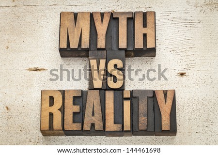 myth versus reality - concept  in vintage letterpress wood type on a grunge painted barn wood background