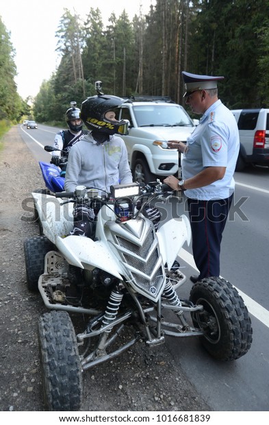 MYTISHCHI, RUSSIA\
- AUGUST 12, 2017: The inspector of the road police patrol stopped\
the ATV driver for\
inspection.