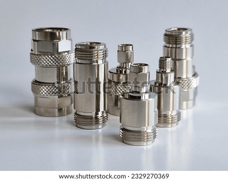 N type and SMA radio frequency coaxial connectors and adapters isolated on gray background