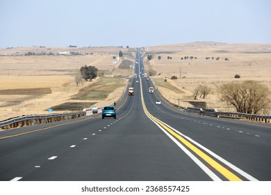 The N3 freeway between Durban and Johannesburg taken from drivers point of view, freeway to the horizon with cars and trucks and dry landscape