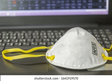 N95 Filtering Face Mask-safty White Mask On Computer Notebook.