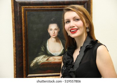 NABEREZHNYE CHELNY - DECEMBER 24, 2013: Opening Of An Exhibition Of Nikas Safronov. Young Woman Next To A Portrait Of Chulpan Khamatova.