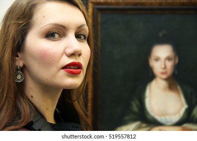 NABEREZHNYE CHELNY - DECEMBER 24, 2013: Opening Of An Exhibition Of Nikas Safronov. Young Woman Next To A Portrait Of Chulpan Khamatova.