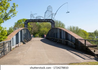NABURN, YORKSHIRE UK, 6 MAY 2020 The 1871 railway swing bridge over the River Ouse at Naburn between York and Selby. Now a cycle path it has a sculpture of a fisherman, dog and cycle added to it.