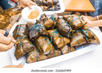 Nacatamales From Nicaragua Being Served On A Plastic Plate To People During A Religious Celebration