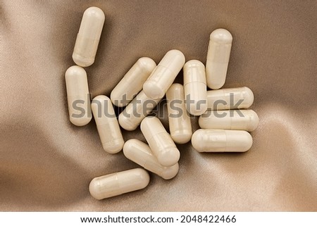 n-acetyl cysteine (NAC) supplement capsules  on silk background. mental wellbeing and personal health concept