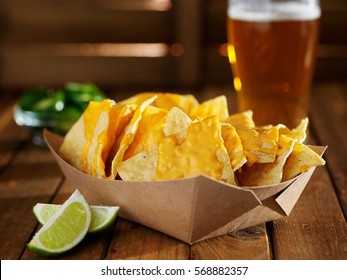 nachos and cheese in tray with beer