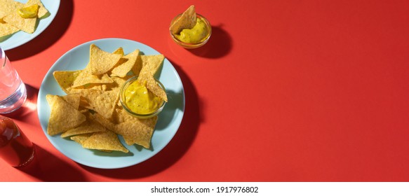 Nachos Chips With Cheese Sauce On Blue Plate On Red Background With Copy Space. Food Photo Banner Format. Concept Roadside Cafe Or Truck Stop Fast Food