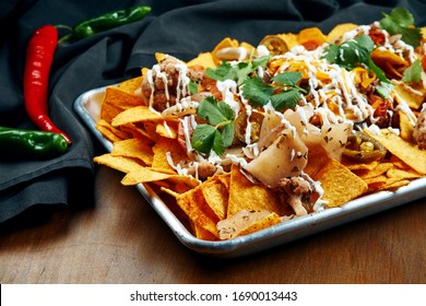Nachos - A classic Mexican appetizer made from corn tortilla chips. Nachos with sauces and holopenya. Top view. Close up.