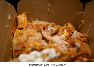 Nachos Covered In Shredded Chicken, Tomato, Green Chilis, Cheddar Cheese, And Sour Cream