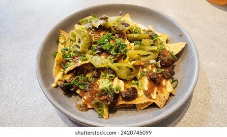 Nachos. Crispy tortilla chips topped with melted cheddar cheese, salsa, black beans, jalapenos, guacamole, sour cream and lettuce. Tex-Mex or Mexican restaurant classic traditional menu item.
 - Powered by Shutterstock