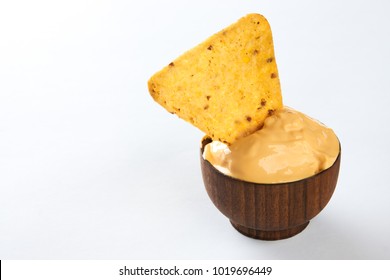 Nachos Dipping Into Wooden Bowl With Creamy Cheese Sauce, Isolated On White Background With Copy Space, Close Up