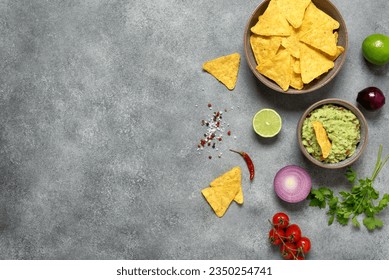 Nachos with guacamole on a gray concrete background. Mexican food. Top view, flat lay, copy space. - Shutterstock ID 2350254741