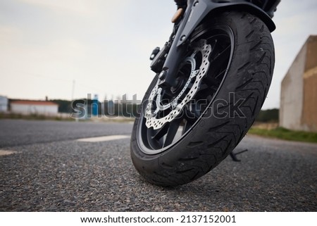 Nacked motorcycle front wheel on a lonely road