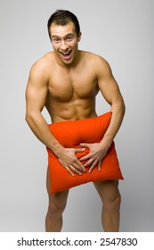 Nacked Smile Man Standing Trying To Hide His Body By Red Pillow Nacked Smile Man Standing Trying To Hide His Body By Red Pillow