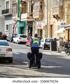 Nadur, Malta - October 19, 2019: Back Turned Maltese Police Officer Riding A Segway