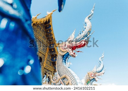 Naga statues at buddhist Blue Temple - tourist attraction in Chiang Rai, Thailand. Temple is known in Thai as Wat Rong Suea Ten