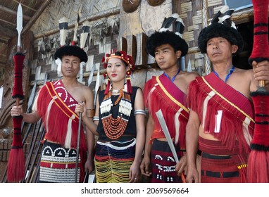 Naga tribesmen and a Naga women dressed in traditional attire with traditional weapons at Kohima Nagaland India on 1 December 2016
