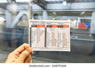 Nagoya, Japan-November 2019, Hand Holding The Ticket And Highway Bus Timetable From Meitetsu Bus Center To Nabana No Sato 2020; Is One Of The Most Popular Illumination Events In Japan During Winter. 