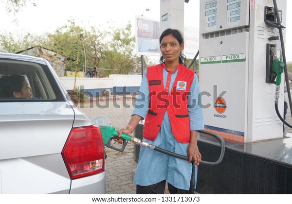 \
NAGPUR, MAHARASHTRA, INDIA - 04 MARCH\
2019: Unidentified Indian Woman pumping gasoline fuel in car at gas\
station. Concept of Women empowerment\
