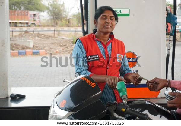 NAGPUR, MAHARASHTRA, INDIA - 04 MARCH 2019:\
Unidentified Indian Woman pumping gasoline fuel in vehical at gas\
station. Concept of Women empowerment\
