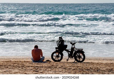 Nahariyya, Israel - October 2020: The man and his bicycle on the Mediterranean beach