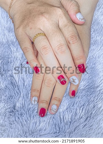 nail art to beautify women's nails, decorated with white color combined with red hearts, on a purple background.