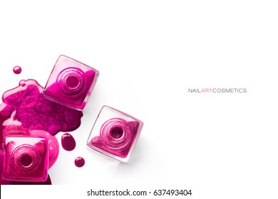Nail art concept. Fine art cosmetics and beauty image with different shades of metallic pink nail polish artistically spilled around three open bottles. Top view isolated on white with copy space