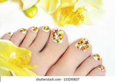 Nail Art Design On Women's Legs With Orchids On A White Background .