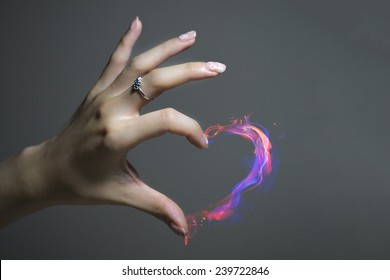 The Nail Art With A Heart Shape Fire. The Finger Is Wearing A Ring For Valentine's Day