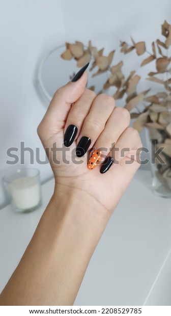 nail decoration in black and orange with dots\
for autumn or halloween