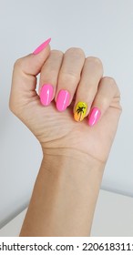 Nail decoration in shades pink and finger in gradient color orange   yellow and palm tree drawn  Photo taken and white background 