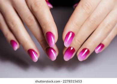 Nail design, manicure with gel polish. Women's hands with a gradient pink manicure. 