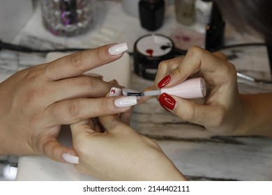 Nail Designer Is Varnishing For The Client