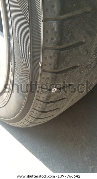 A nail inside tire that made flat tire.\
Accident with punctured tires\
concept.\
\
