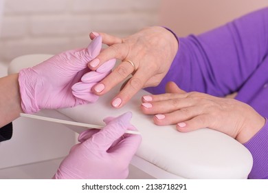 
Nail Master In Gloves Holding Old Woman Hands With Manicure Nails In Beauty Salon